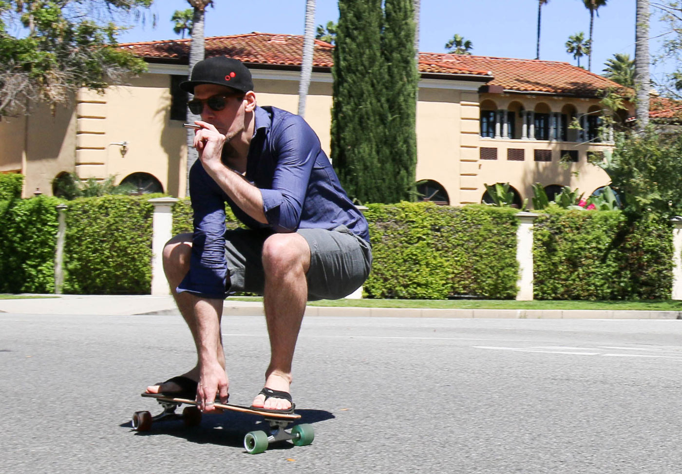 Skateboarder smokes a vaporizer while riding